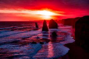panoramic view of the twelve apostles rocks against the backdrop of a red sunset
