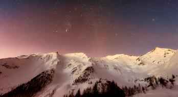 stars in colorful sky above snowy Mountains