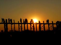 Silhouettes of the people, on the bridge in Burma, at beautiful and colorful sunset