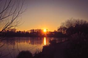 Scenic photo of sunset over a forest lake