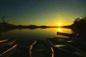 boats on the shore of the lake against the background of sunset