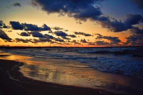 beach with waves during sunset in poland