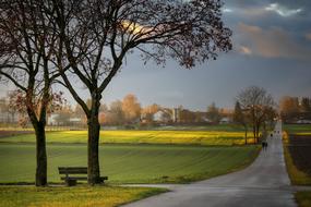 stormy sky over road through green meadow