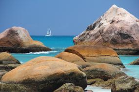 distant view of a sailboat off the coast of the seychelles