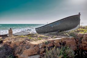 fishing boat on a rocky shore on a sunny day