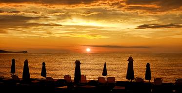 closed parasols on beach at Sunset, greece, lesbos