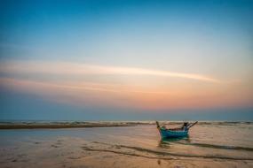 sunset over a boat on the coast in the tropics