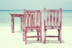 wooden table and chairs on a tropical beach