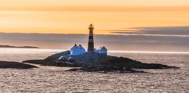 Landegode lighthouse on rocky island at sunset, Norway