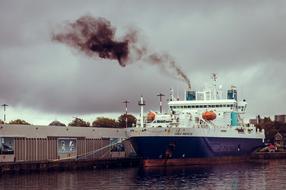 ship with black smoke at the dock