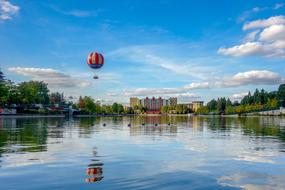 hot-air balloon over pond in city