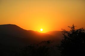 photo of yellow evening sky over the hills