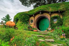 Beautiful hobbit house among the colorful plants and flowers