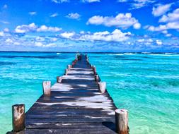 Beautiful pier of the beautiful beach among the beautiful and colorful water in Mexico