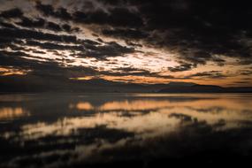 sunset in dark clouds over the lake