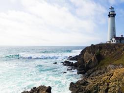 Beautiful cliff coast with the lighthouse among the beautiful water with waves