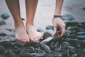 Feet Hand on stones on Beach
