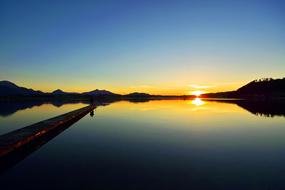 Beautiful landscape of the lake, among the trees, at colorful and beautiful sunset, in the evening