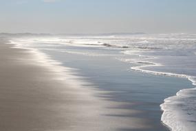 Beautiful sandy beach with waves in New Zealand