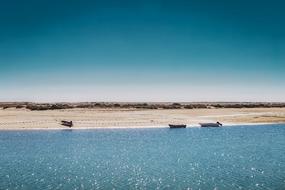 Boats on the water near the shore with light reflections