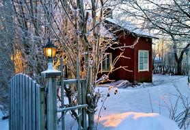 House with beautiful lantern on the fence among the stone on beautiful winter landscape with the Christmas Spirit