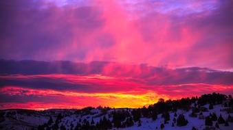 panorama of snowy mountains against a pink-purple sky in Utah