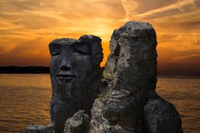 image of a person on a rock by the sea on a sunset background