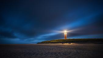 distant view of the lighthouse on the north sea coast at night