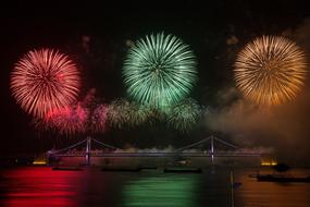 tricolor lights of festive fireworks over the bridge at night