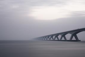 arches of concrete bridge in dense fog