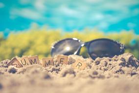 wooden cubes and sunglasses on the sand