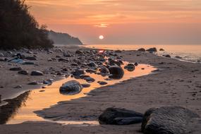 Beautiful beach of RÃ¼gen with stones at beautiful and colorful sunset background in Germany