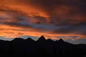 orange clouds and blue sky over mountains
