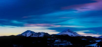 snow-capped mountains under the clouds in winter