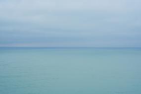 calm blue sea beneath cloudy sky