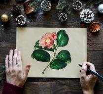 painted flower on a white sheet on a table with cones