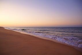 Beautiful beach at beautiful and colorful sunrise in Faro, Portugal