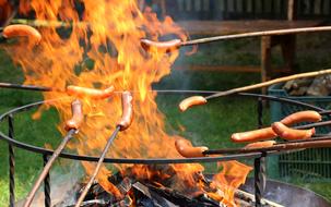 sausages are fried on a flame