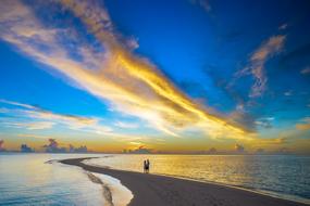 Silhouette of the couple on the beautiful coast at beautiful and colorful sunset