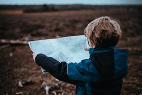 photo of a boy with a map outdoors