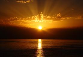 bright streak of the sun on the surface of the sea against a golden sunset