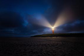 distant view of lighthouse on cloudy night
