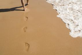 walk barefoot along the sand along the ocean