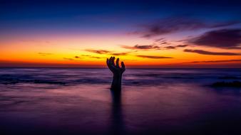 Hand on the beautiful beach at beautiful and colorful sunset in Pohang, South Korea