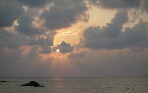 Beautiful waterscape with rocks at beautiful and colorful sunset background in the clouds