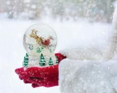 christmas ball in the hands of snowy winter