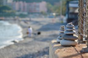 balancing stone towers on the beach