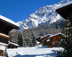 Beautiful landscape with the snowy chalets in Leysin, Switzerland, among the trees, on the mountains