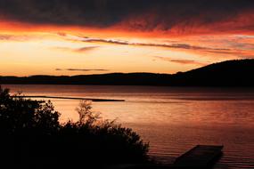 dark clouds and red sunset over the lake