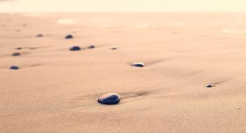 pebbles on pink sand in blurred background